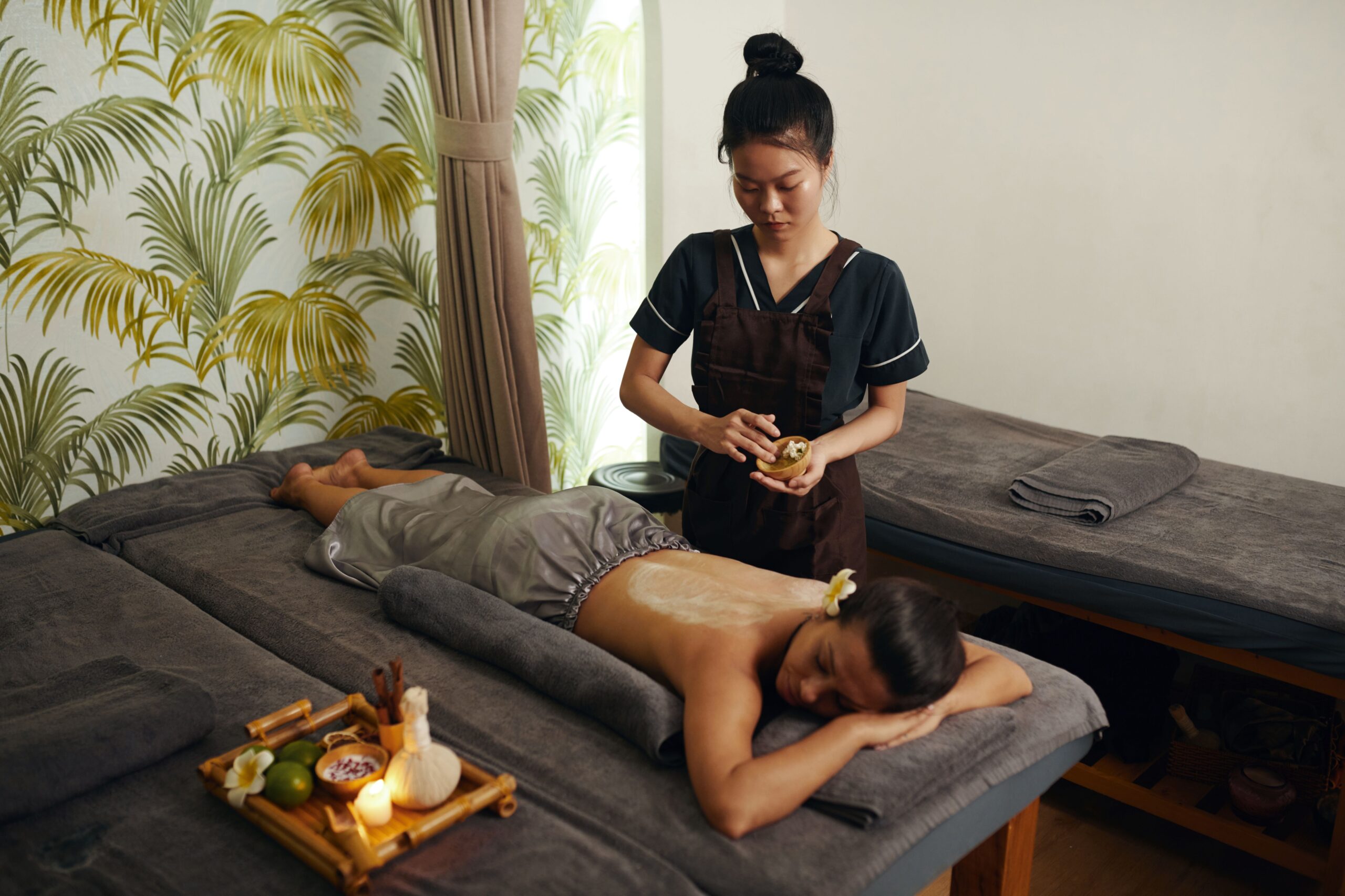 A calm treatment room with two linen-dressed massage tables
